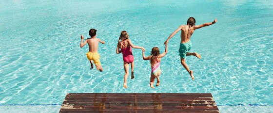 Lapset hyppäämässä laiturilta veteen