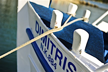 Lähikuva sini-valkoisen veneen nimestä keulassa.