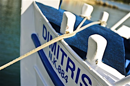 Lähikuva sini-valkoisen veneen nimestä keulassa.
