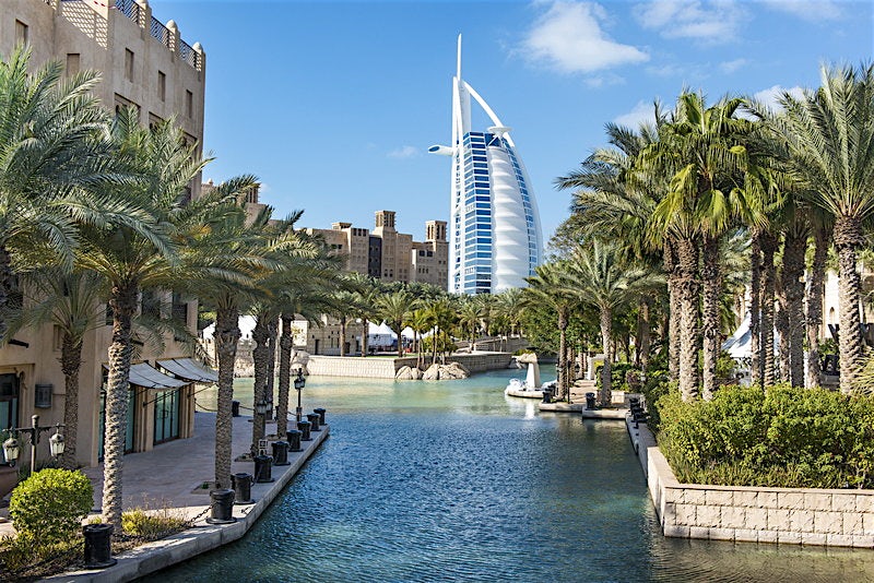 Kanava ja palmupuita Dubain kaupungissa, taustalla Burj Al Arab -hotelli