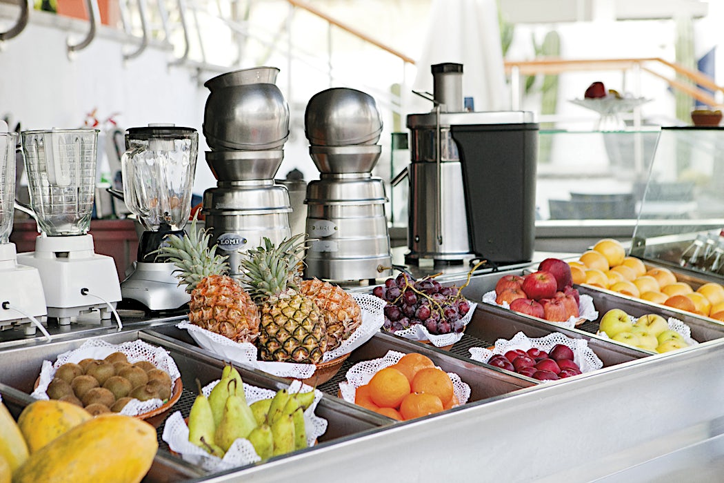 Hotellin aamiaisbuffet, jossa hedelmiä, mehuja ja smoothieaineksia