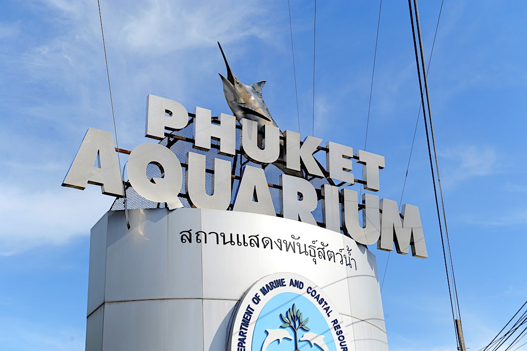 Phuket Aquarium -kyltti sinistä taivasta vasten.