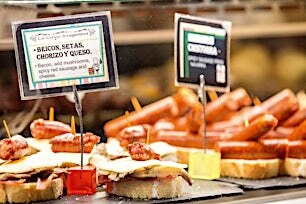 Läheltä otettu kuva espanjalaisista tapaksista, joissa juustoja ja makkaraa