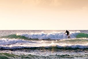 Surffaaja aallolla auringonlaskussa