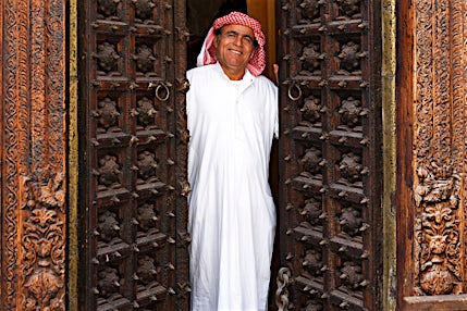 Perinteisesti pukeutunut arabimies seisoo oviaukossa.