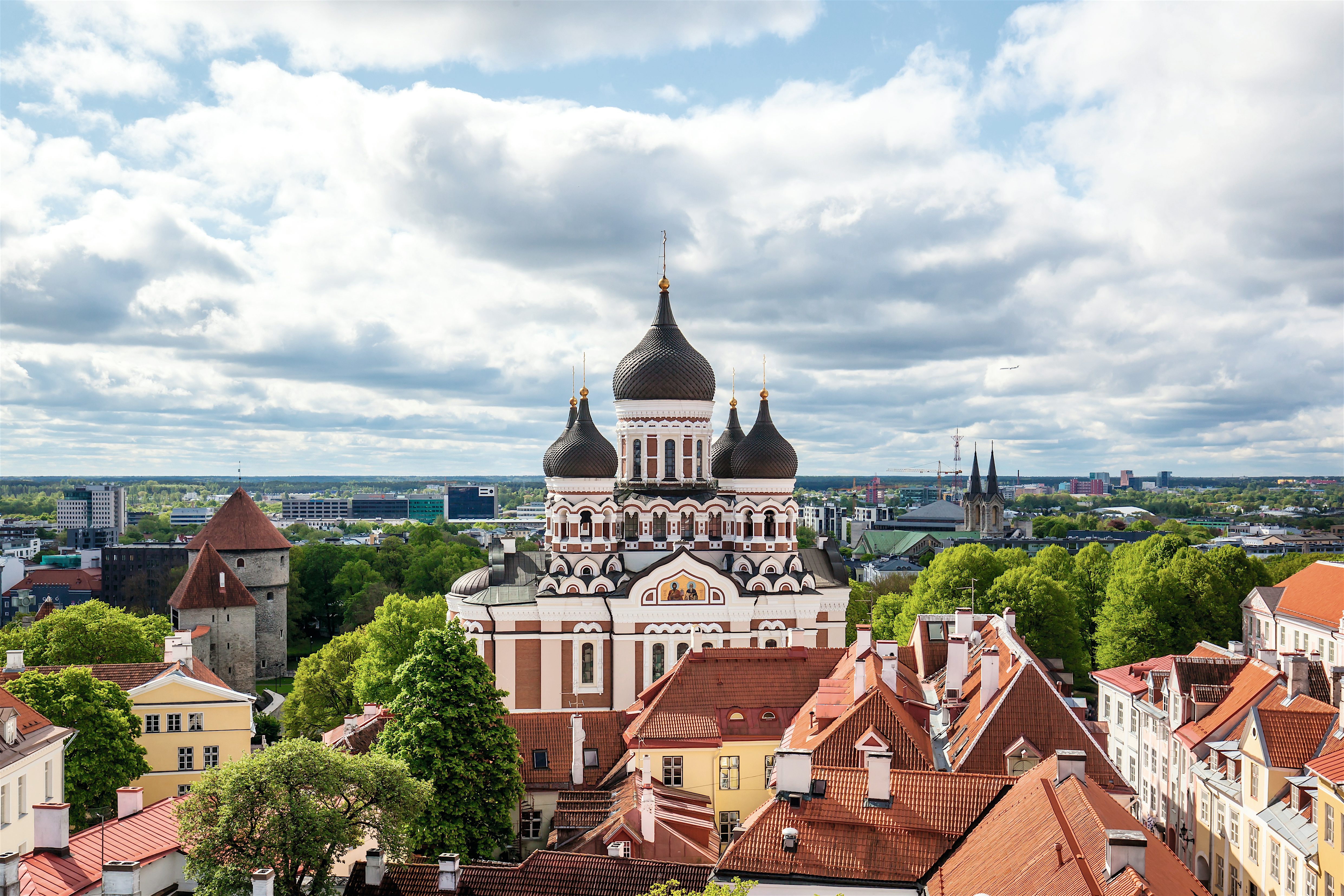 Aleksanteri Nevskin katedraali ja rakennusten kattoja Tallinnassa pilvisen taivaan alla.