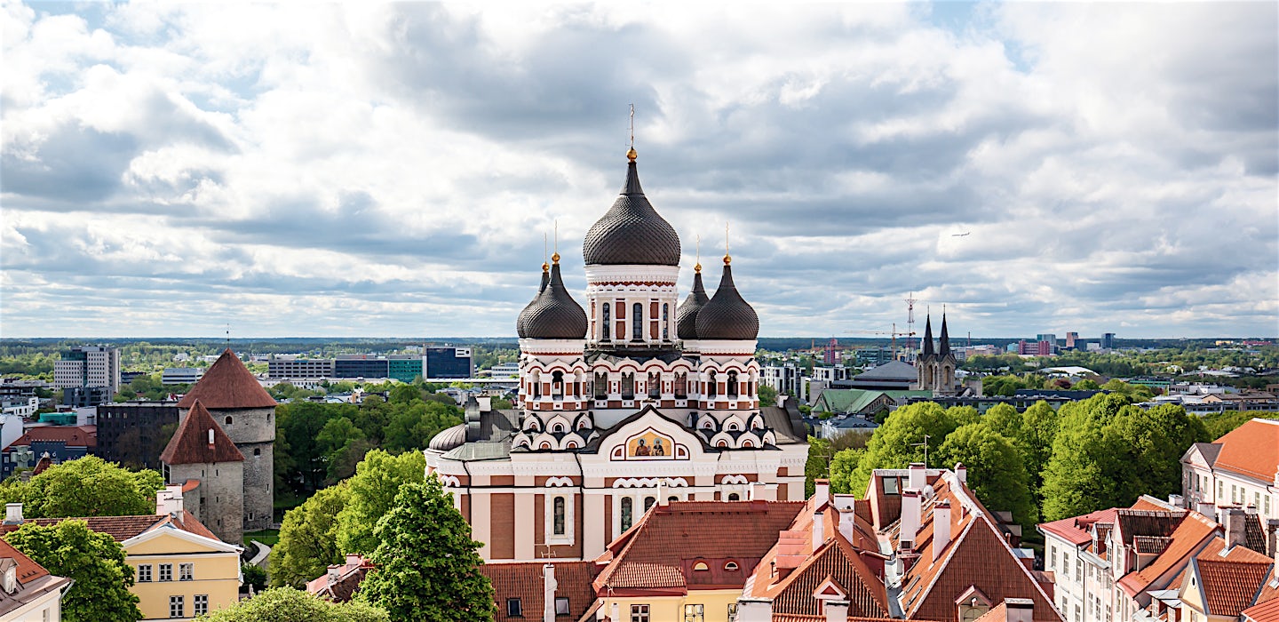 Aleksanteri Nevskin katedraali ja rakennusten kattoja Tallinnassa pilvisen taivaan alla.