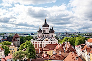 Aleksanteri Nevskin katedraali ja rakennusten kattoja Tallinnassa pilvisen taivaan alla.