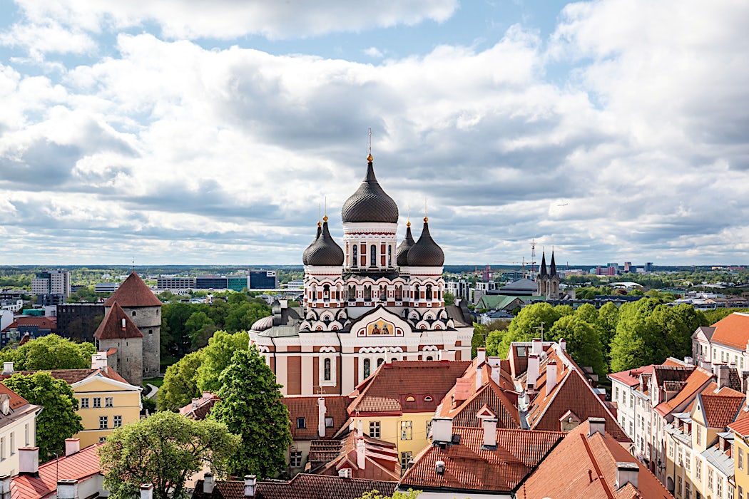 Aleksanteri Nevskin katedraali ja rakennusten kattoja Tallinnassa pilvisen taivaan alla.