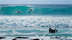 kaksi surffaajaa suurissa aalloissa